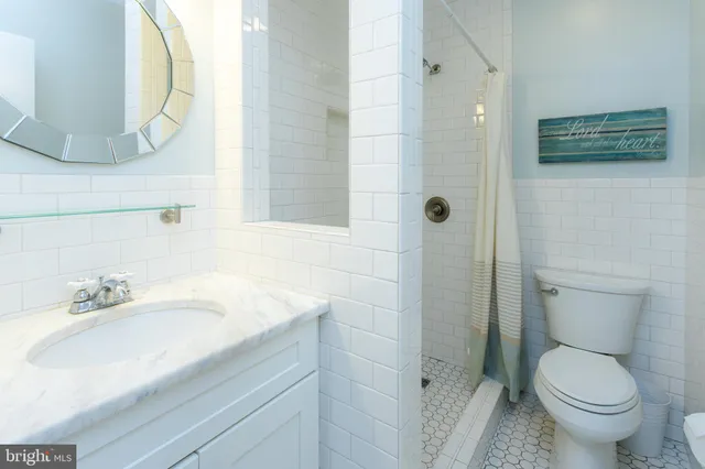 a bathroom with a sink a toilet and mirror
