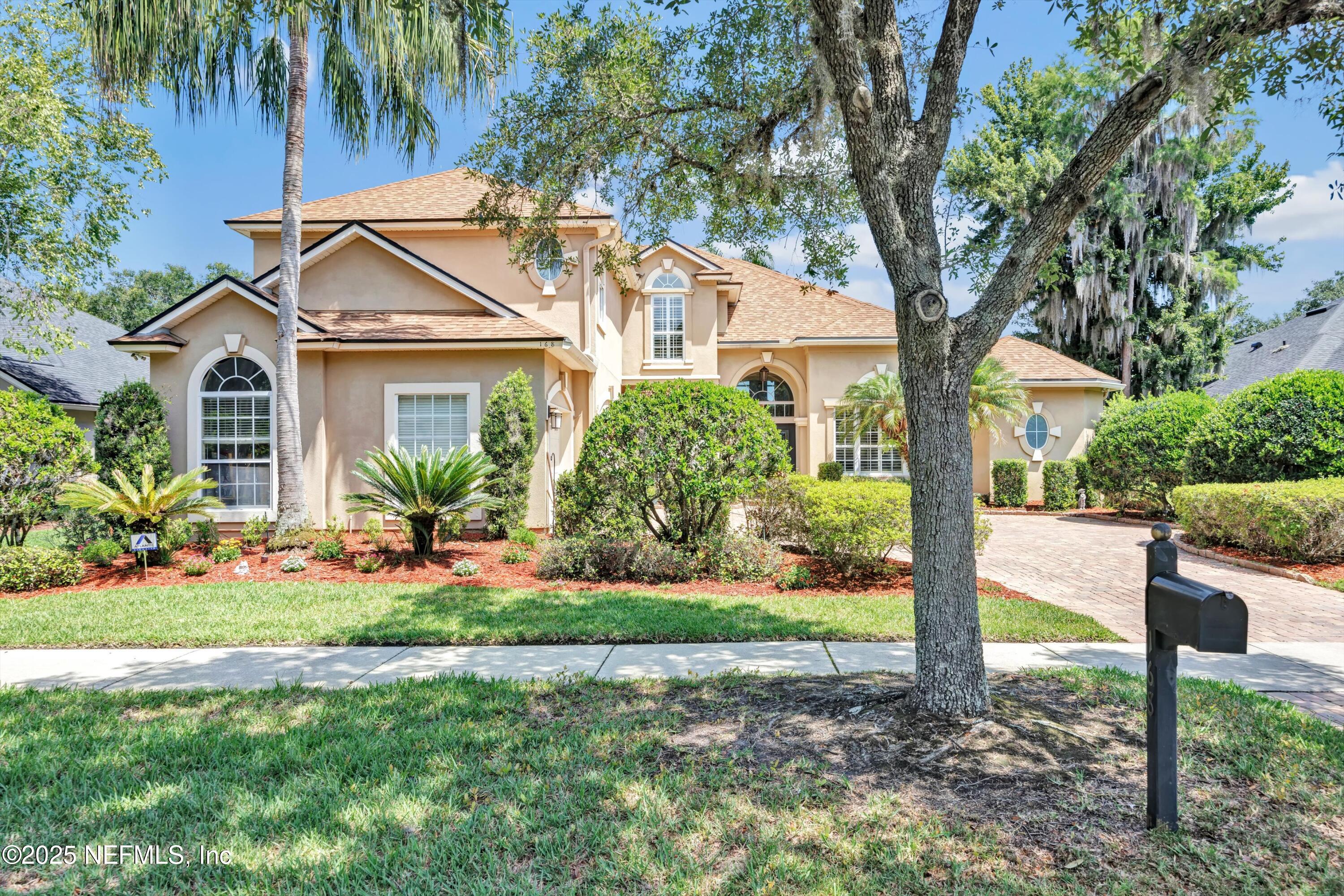 a front view of a house with a yard and potted plants