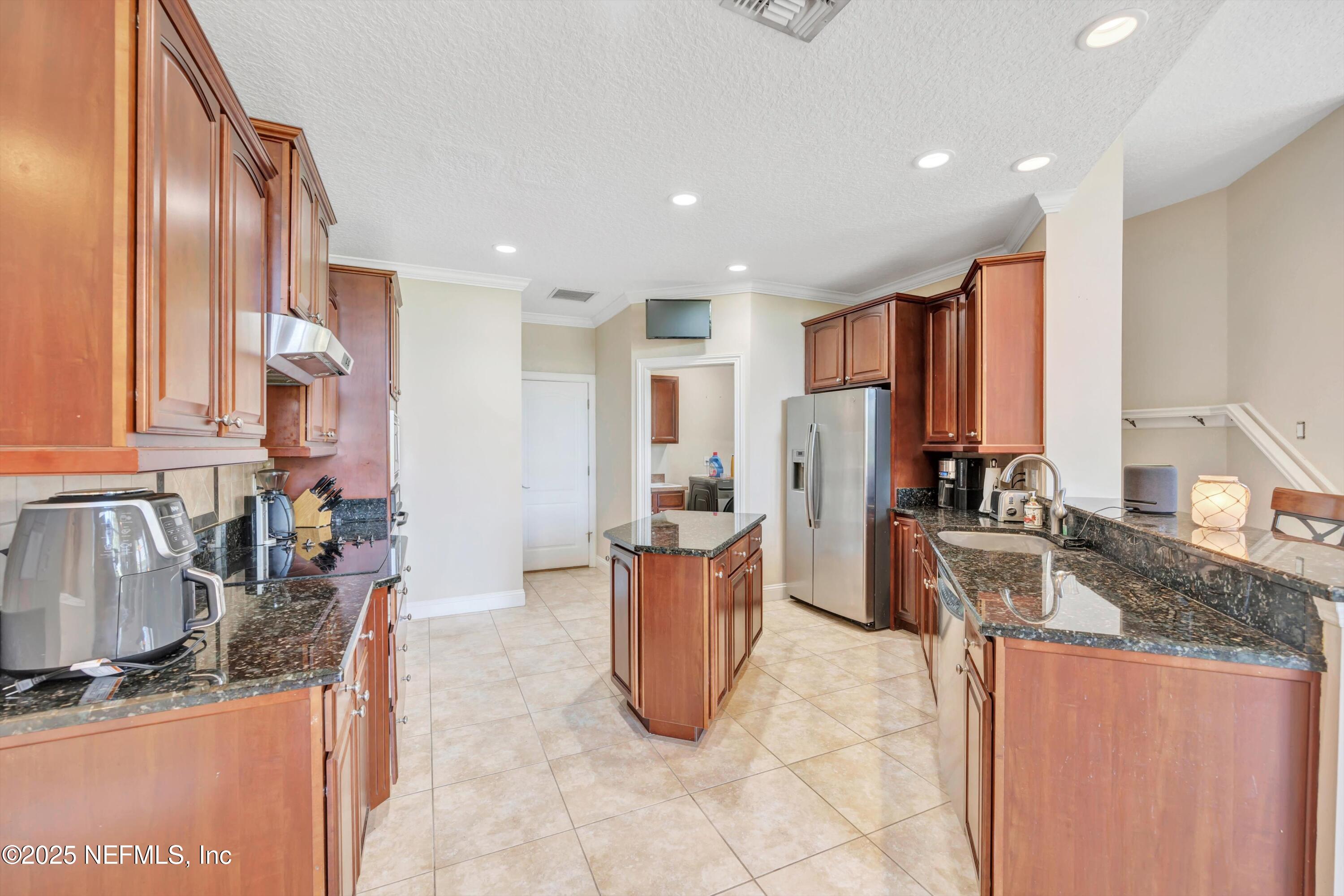 168 Pinehurst Pointe Drive St. Augustine, FL 32092 - Photo 16 of 72 a kitchen with stainless steel appliances granite countertop sink stove refrigerator and cabinets