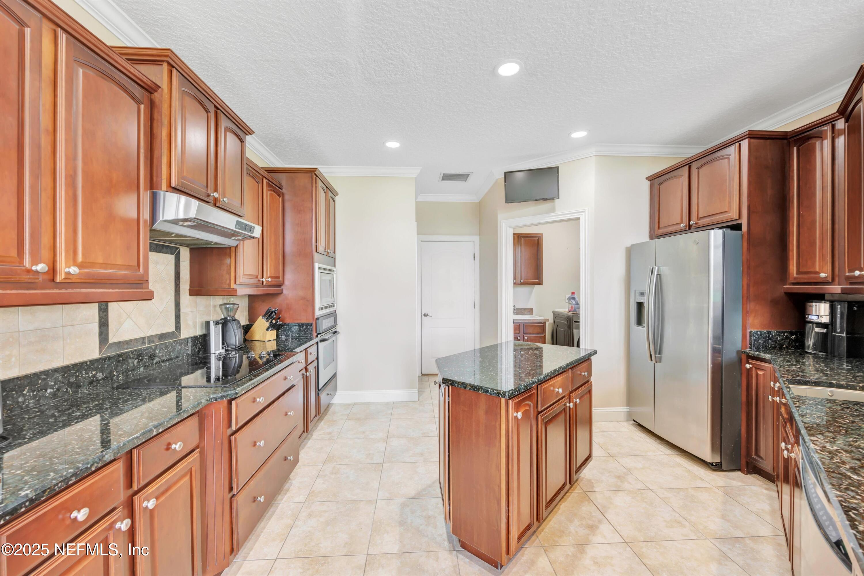 168 Pinehurst Pointe Drive St. Augustine, FL 32092 - Photo 19 of 72 a kitchen with stainless steel appliances granite countertop a refrigerator and a stove top oven