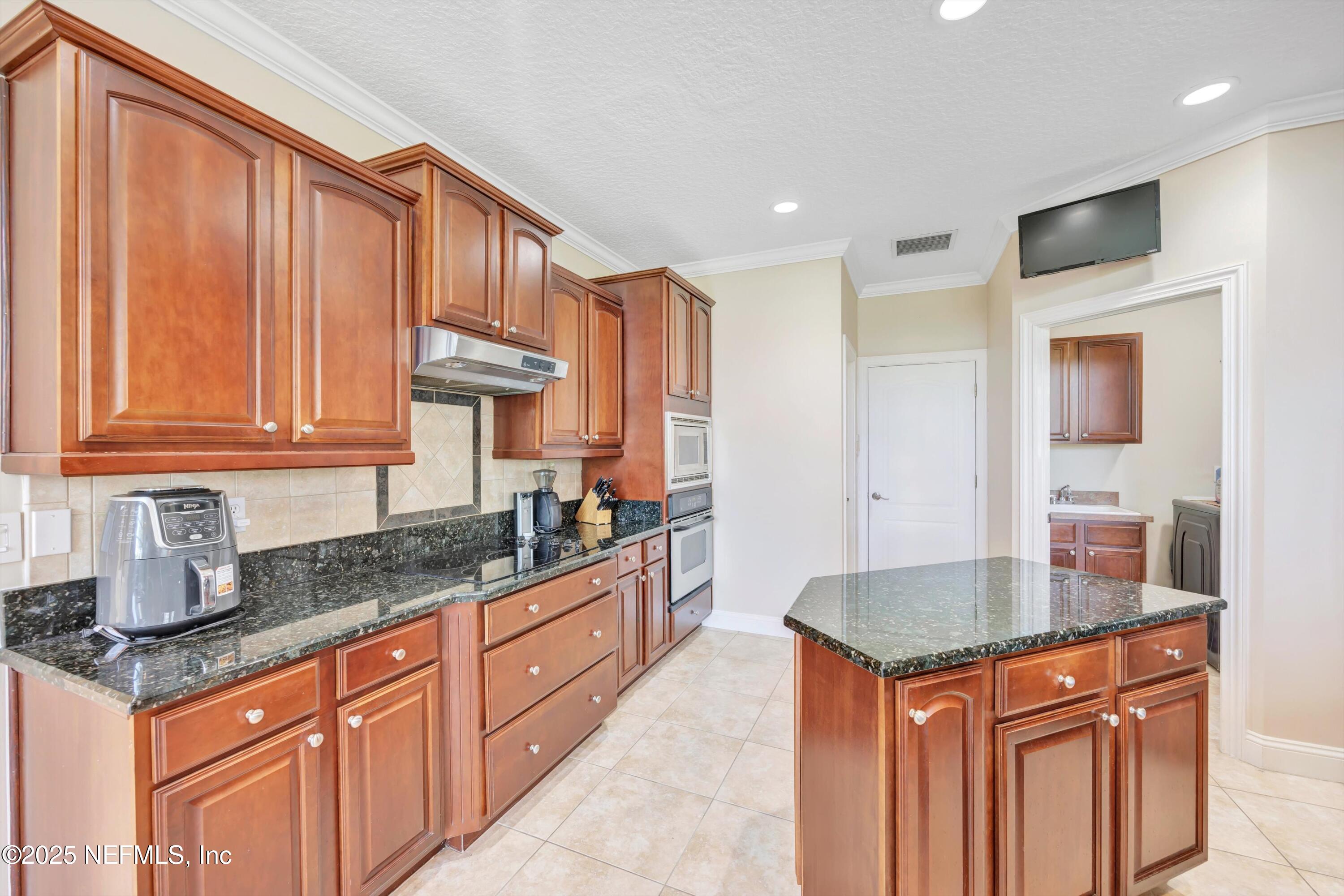 168 Pinehurst Pointe Drive St. Augustine, FL 32092 - Photo 20 of 72 a kitchen with stainless steel appliances granite countertop a sink a stove and cabinets