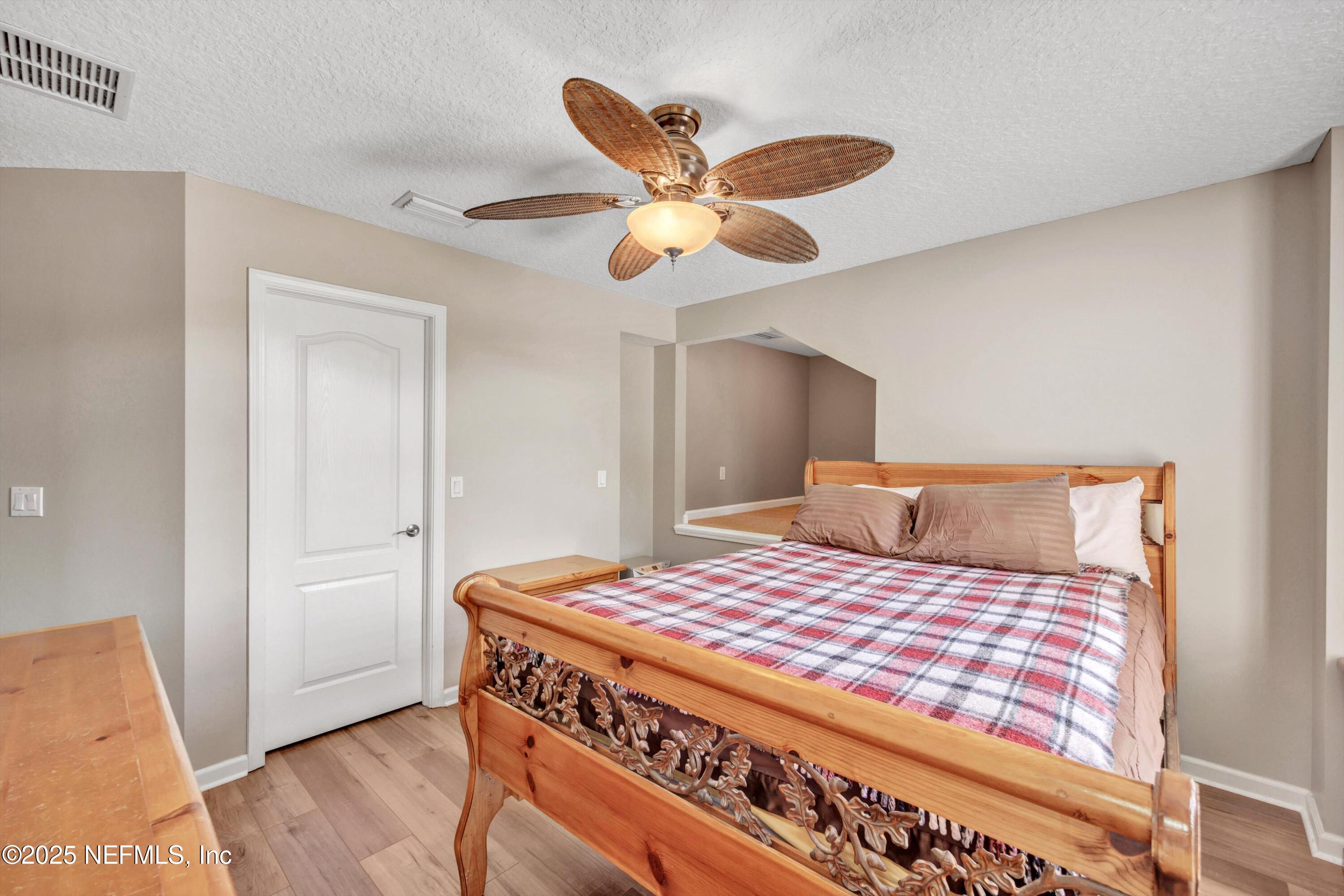 168 Pinehurst Pointe Drive St. Augustine, FL 32092 - Photo 36 of 72 a bedroom with a bed and a chandelier