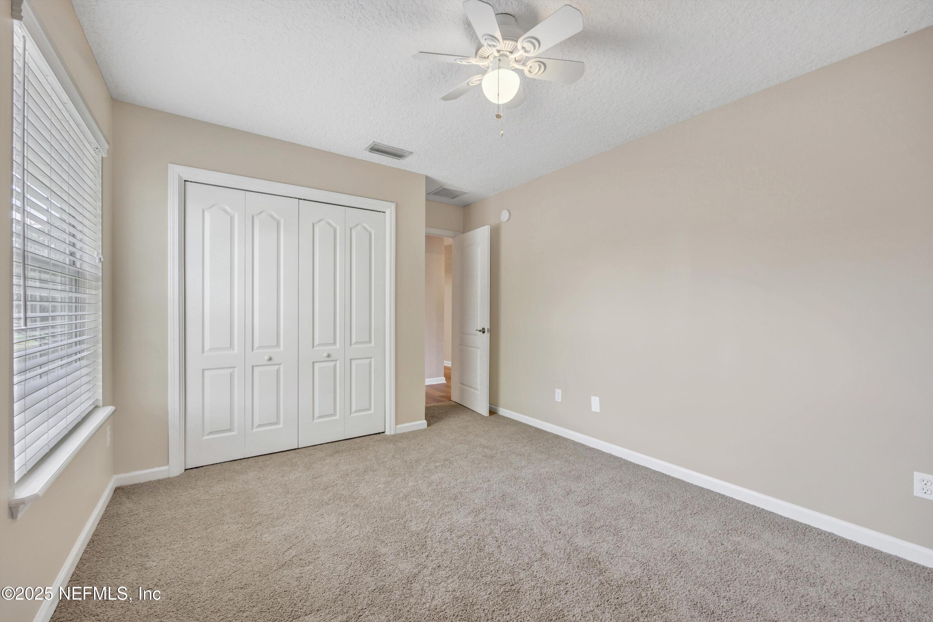 168 Pinehurst Pointe Drive St. Augustine, FL 32092 - Photo 44 of 72 an empty room with a ceiling fan and a window