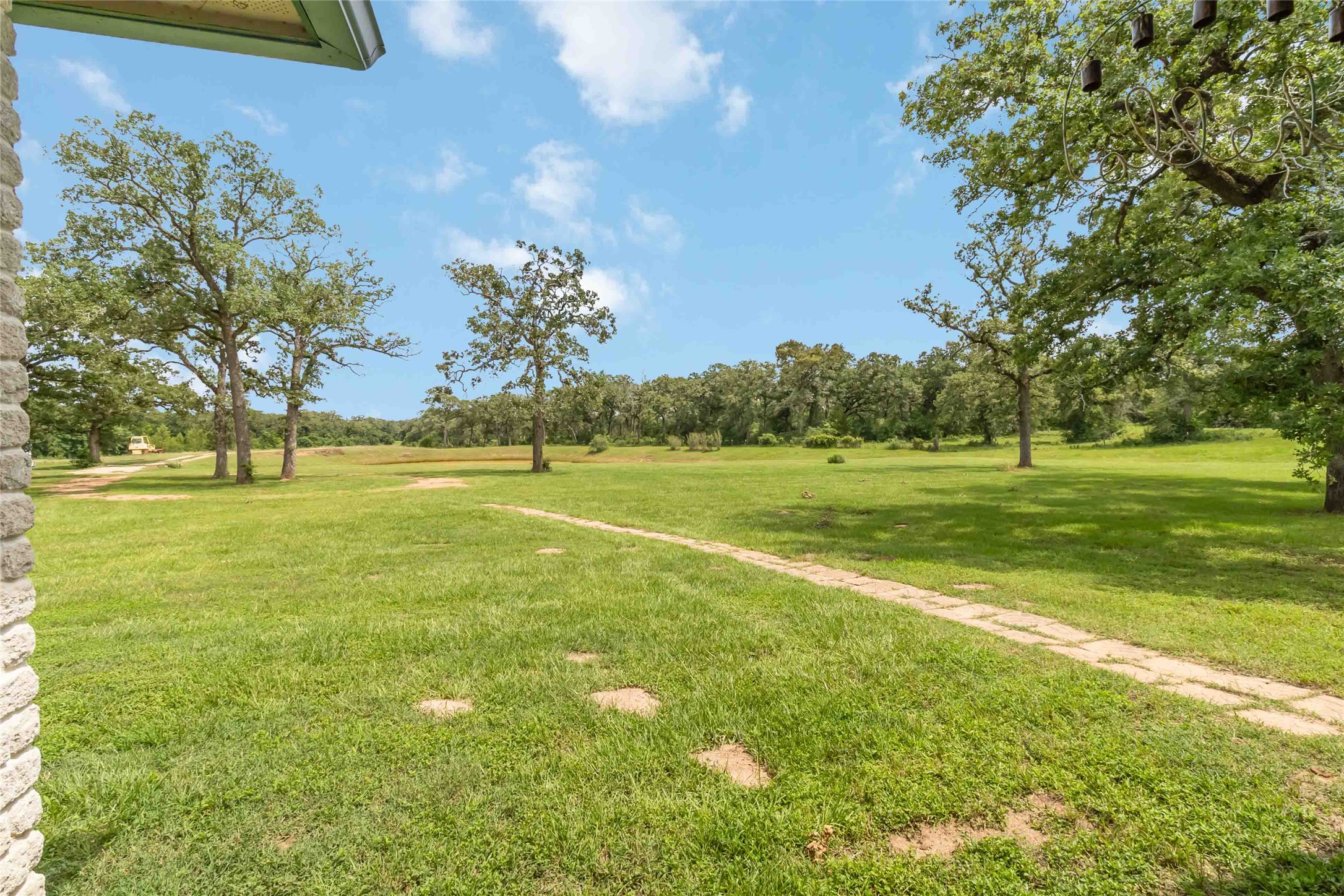 1208 Jeddo Road Rosanky, TX 78953 - Photo 27 of 40 Green pastures and mature trees stretch under a brilliant blue sky.