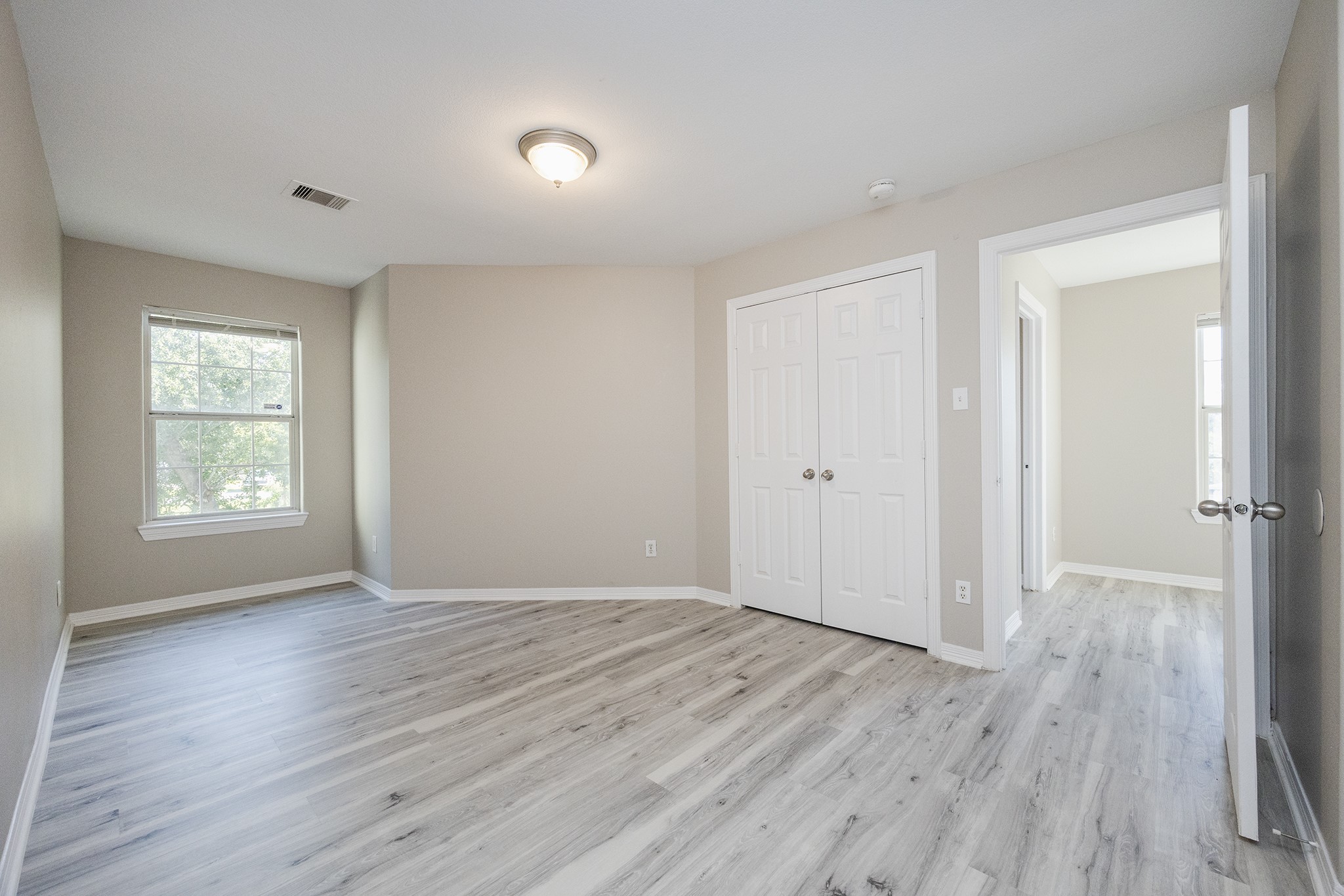4624 Larkspur Street, Unit B Houston, TX 77051 - Photo 31 of 49 an empty room with wooden floor and windows