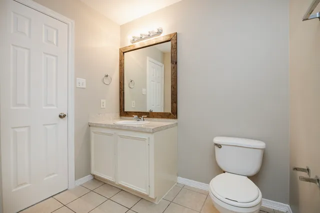 a bathroom with a toilet a sink and a mirror