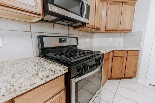 a stove top oven sitting inside of a kitchen