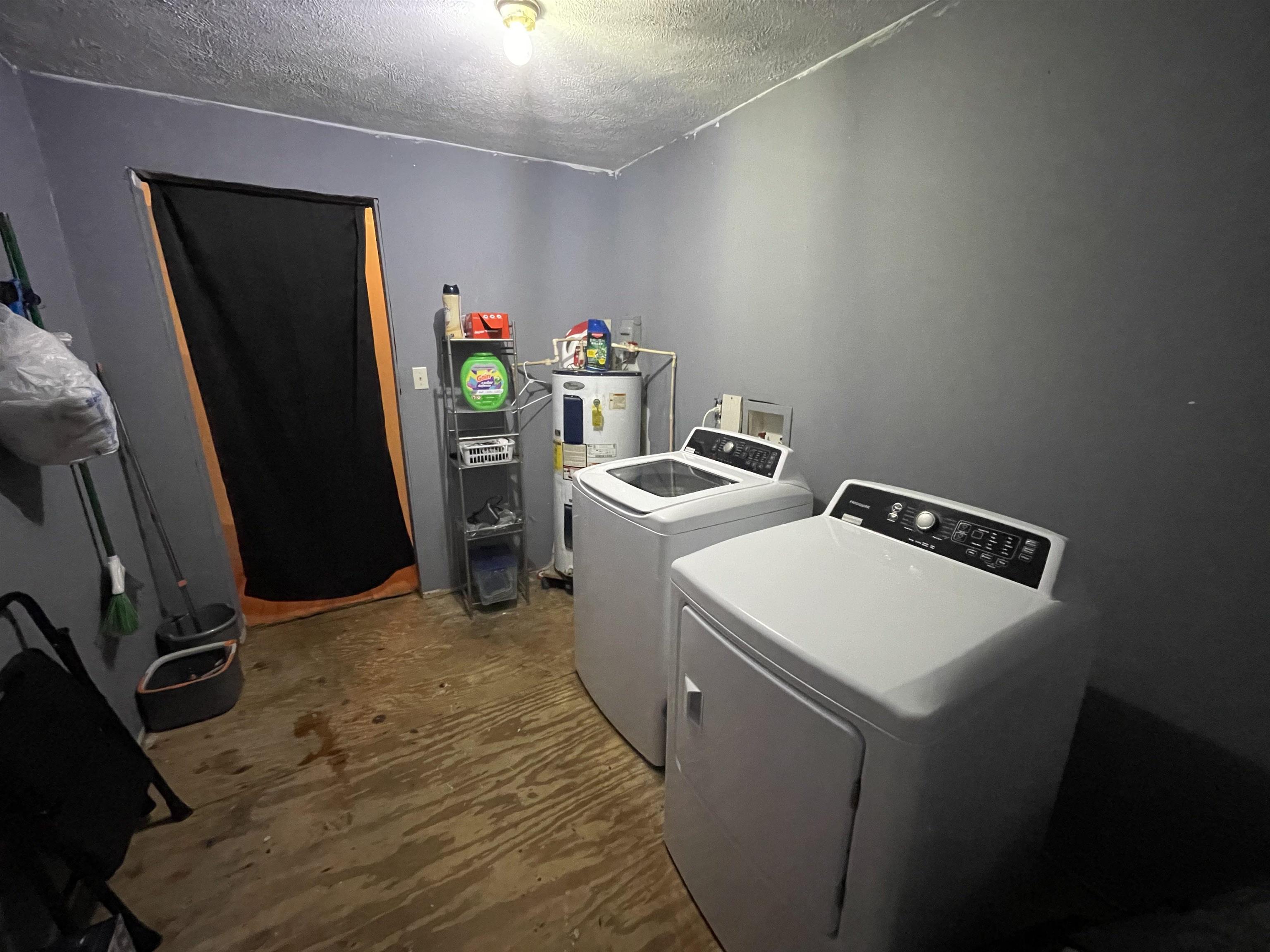 765 Foster Road Adamsville, TN 38310 - Photo 7 of 23 Laundry area featuring washing machine and dryer, water heater, a textured ceiling, and laundry area