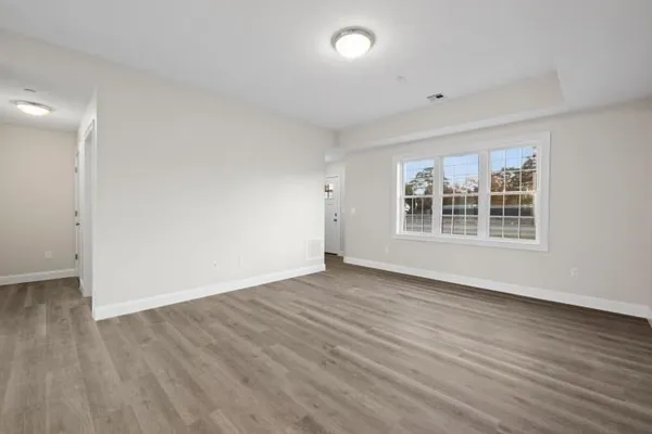 wooden floor in an empty room with a window