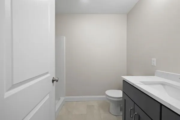 a bathroom with a granite countertop toilet and a sink