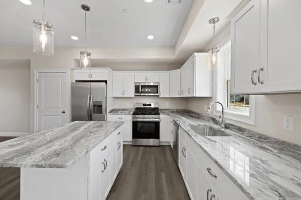 a large kitchen with cabinets stainless steel appliances a sink and a stove