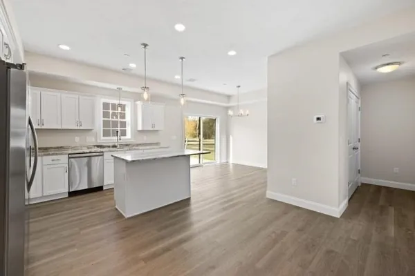 a kitchen with a refrigerator and white cabinets