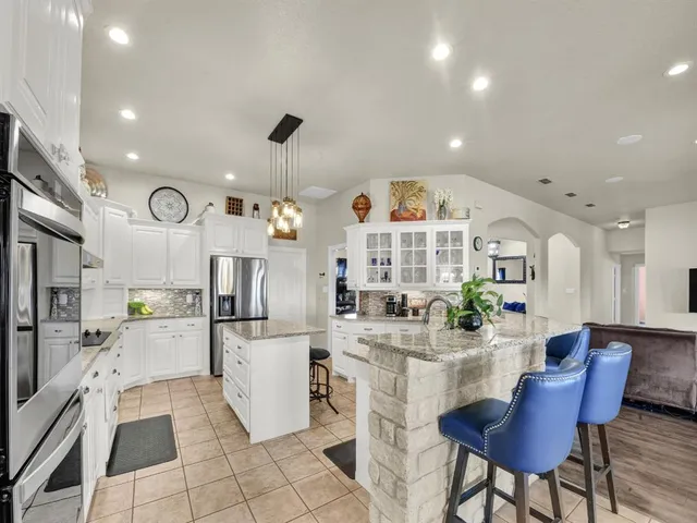 a spacious bathroom with a granite countertop sink a mirror a bathtub and shower