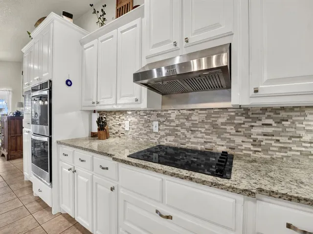 a view of a kitchen with refrigerator and white cabinets