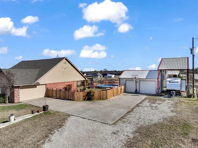 an aerial view of a house with swimming pool and a yard