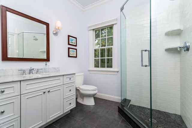 a bathroom with a toilet sink a mirror and window