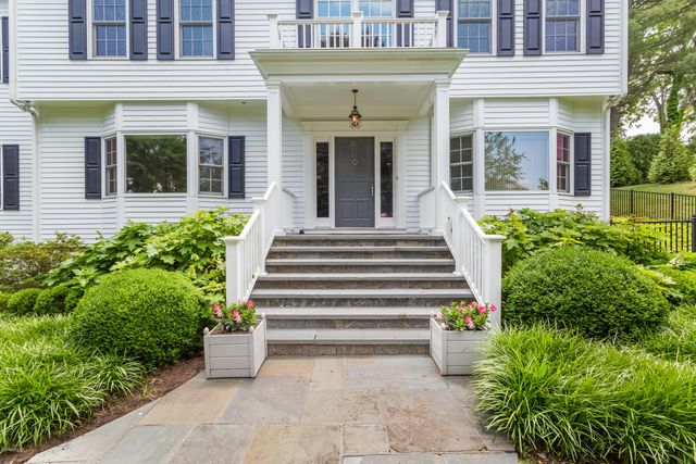 a front view of a house with plants and large windows