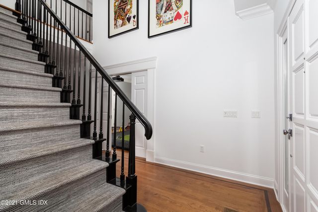a view of staircase with wooden floor and white walls