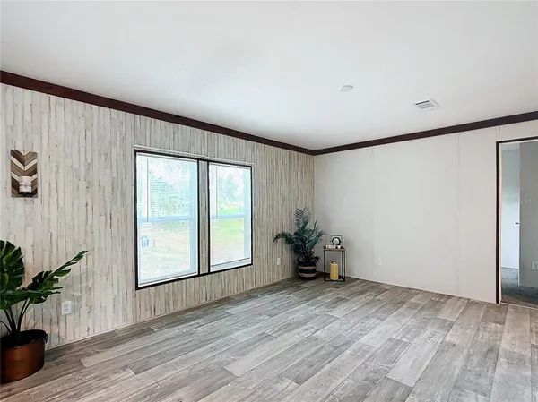 an empty room with wooden floor and a window
