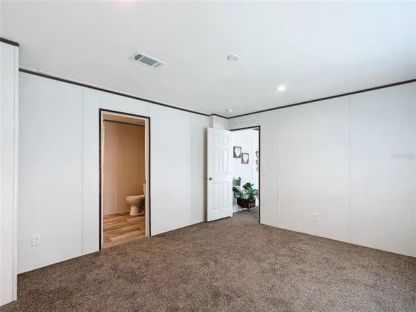 an empty room with closet and windows