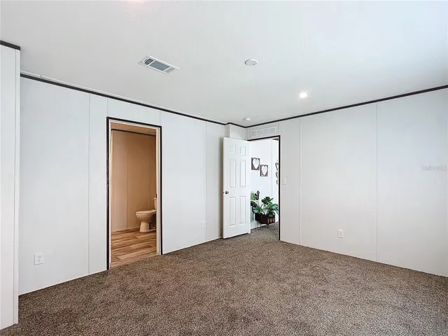 an empty room with closet and windows