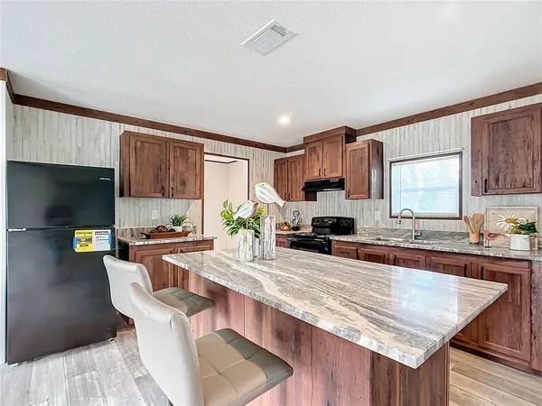 a kitchen with stainless steel appliances granite countertop a sink stove and refrigerator