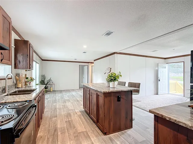 a kitchen with granite countertop a stove and a wooden floor