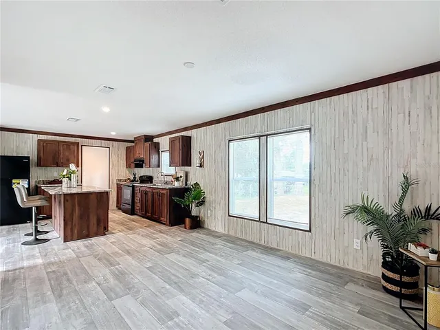 a large open kitchen with stainless steel appliances kitchen island a large counter top and a wooden floors