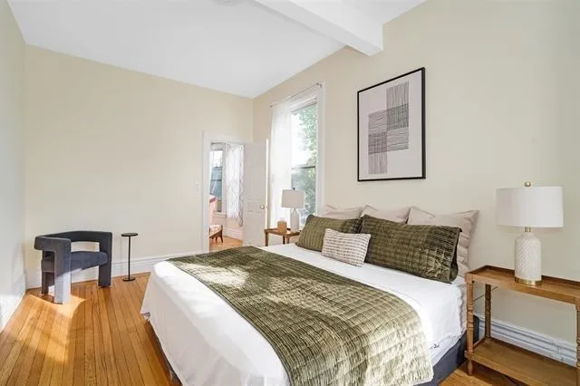 a bedroom with a bed and wooden floor