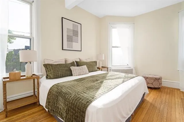 a bed sitting in a bedroom next to a window