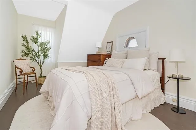 a bedroom with a bed and a potted plant