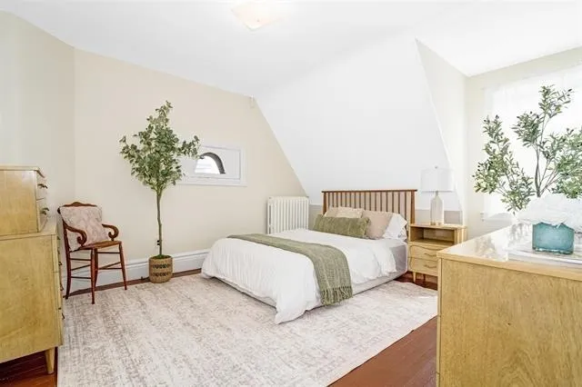 a bedroom with a bed and a potted plant