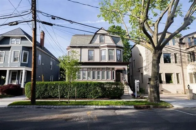 a view of a white building among the street and trees