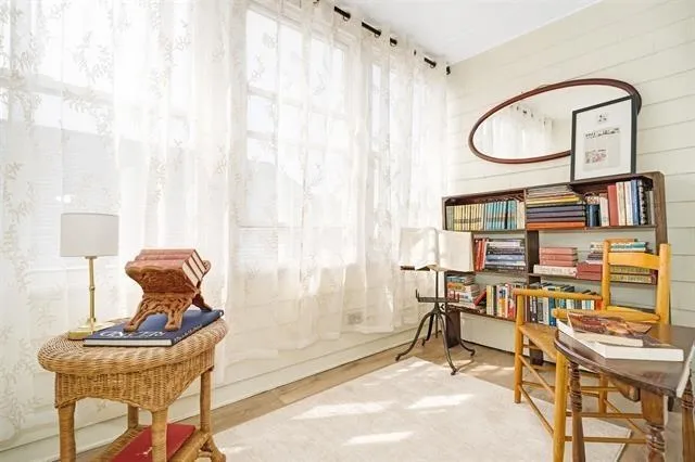 a room with chandelier fan and windows