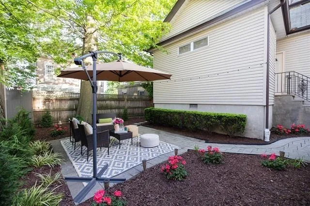 a view of a patio with couches table and chairs under an umbrella