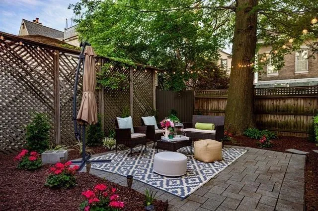 a view of a patio with couches and a table and chairs with wooden fence