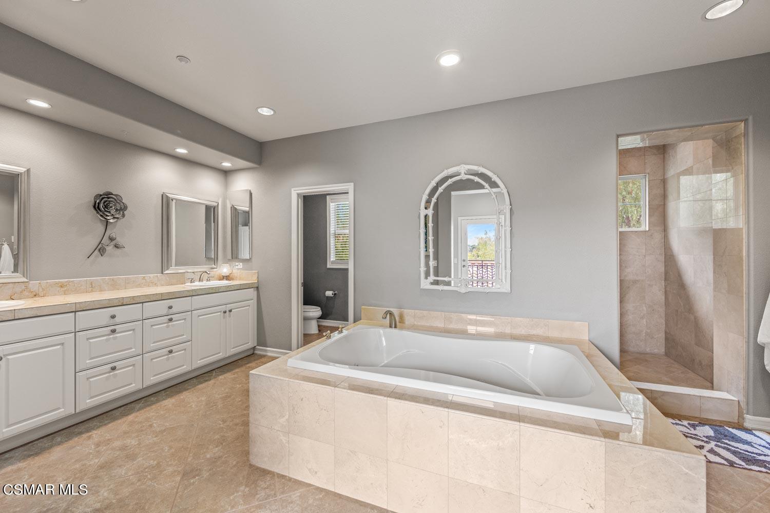 413 Vineyard Drive Simi Valley, CA 93065 - Photo 12 of 26 a spacious bathroom with a tub sink and mirror