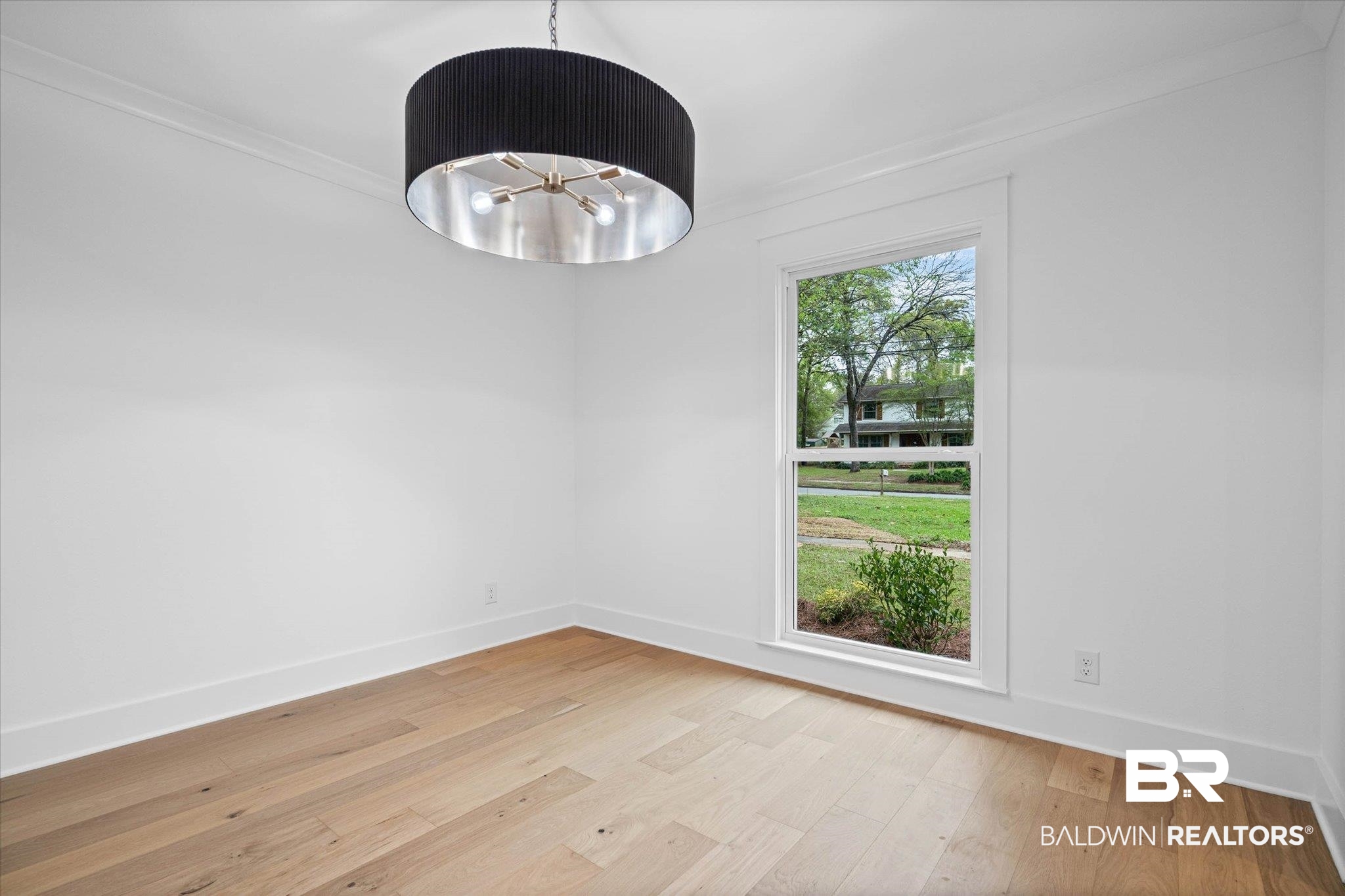 11 Schwaemmle Drive Mobile, AL 36608 - Photo 9 of 32 Empty room with hanging lights, light wood-style floors, and crown molding