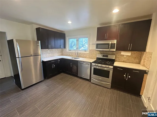 a kitchen with a refrigerator sink and wooden floor