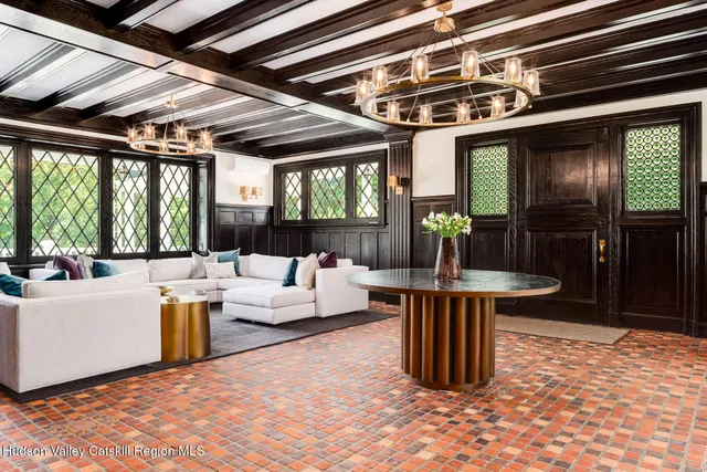 a view of a dining room with furniture a chandelier and wooden floor