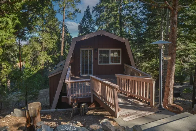 a view of a house with a small yard and wooden fence