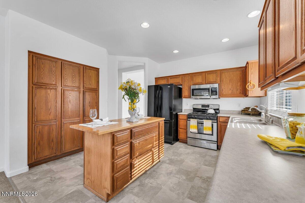 9765 Rock River Drive Reno, NV 89506 - Photo 8 of 25 a kitchen with stainless steel appliances granite countertop a stove top oven a refrigerator a sink and dishwasher