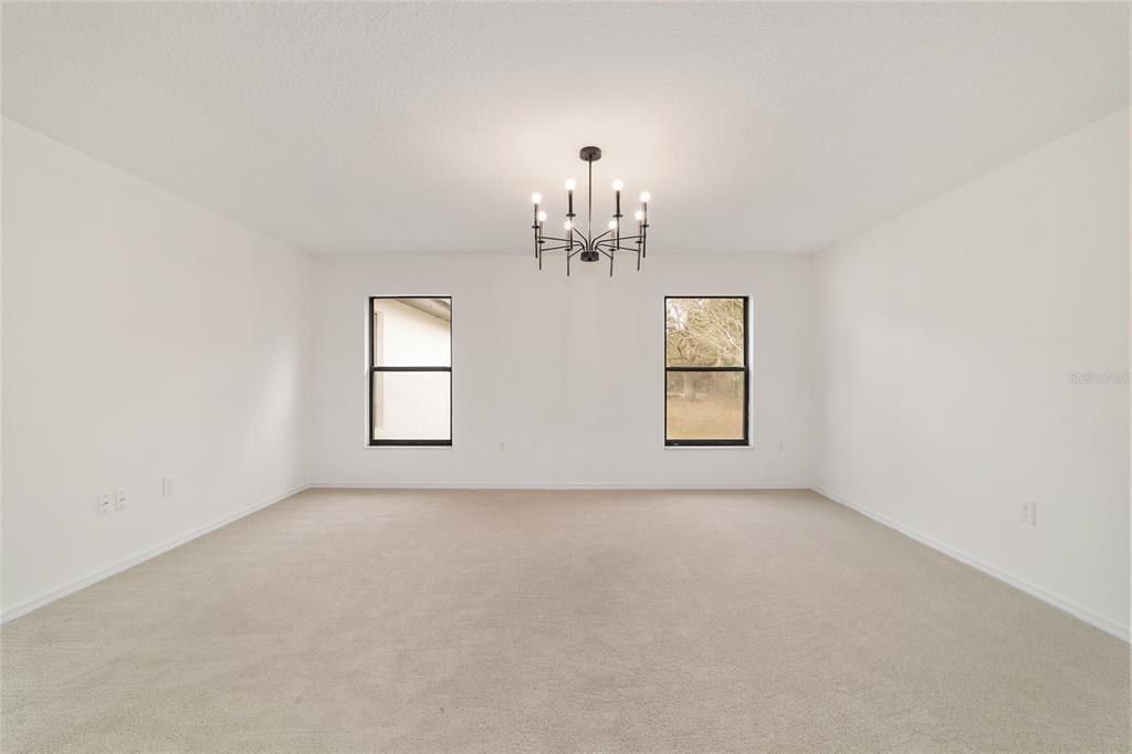 10575 Southwest 27th Avenue Ocala, FL 34476 - Photo 17 of 95 an empty room with windows and chandelier fan