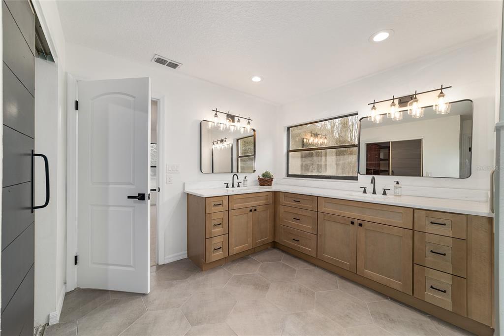 10575 Southwest 27th Avenue Ocala, FL 34476 - Photo 21 of 95 a spacious bathroom with a double vanity sink mirror and bathtub