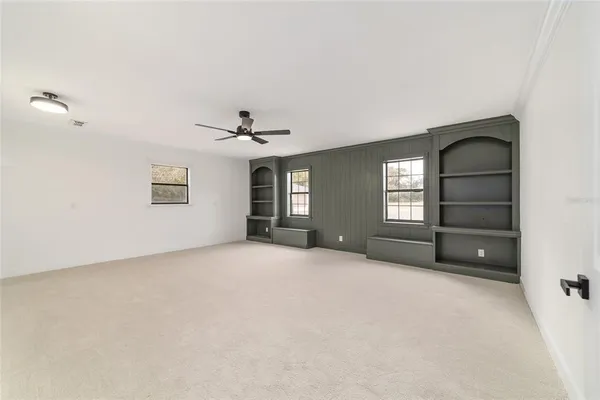 a view of an empty room with a fireplace and a window