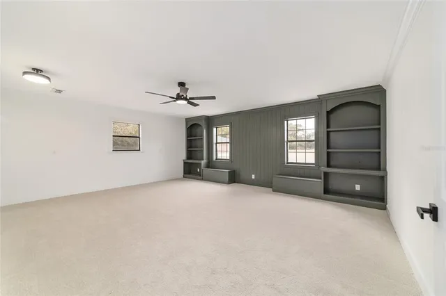 a view of an empty room with a fireplace and a window