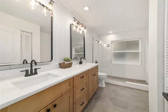a kitchen with a refrigerator a sink and wooden floor