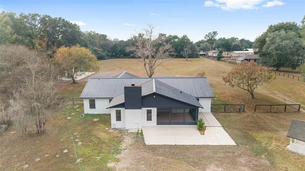 a view of a house with backyard and trees