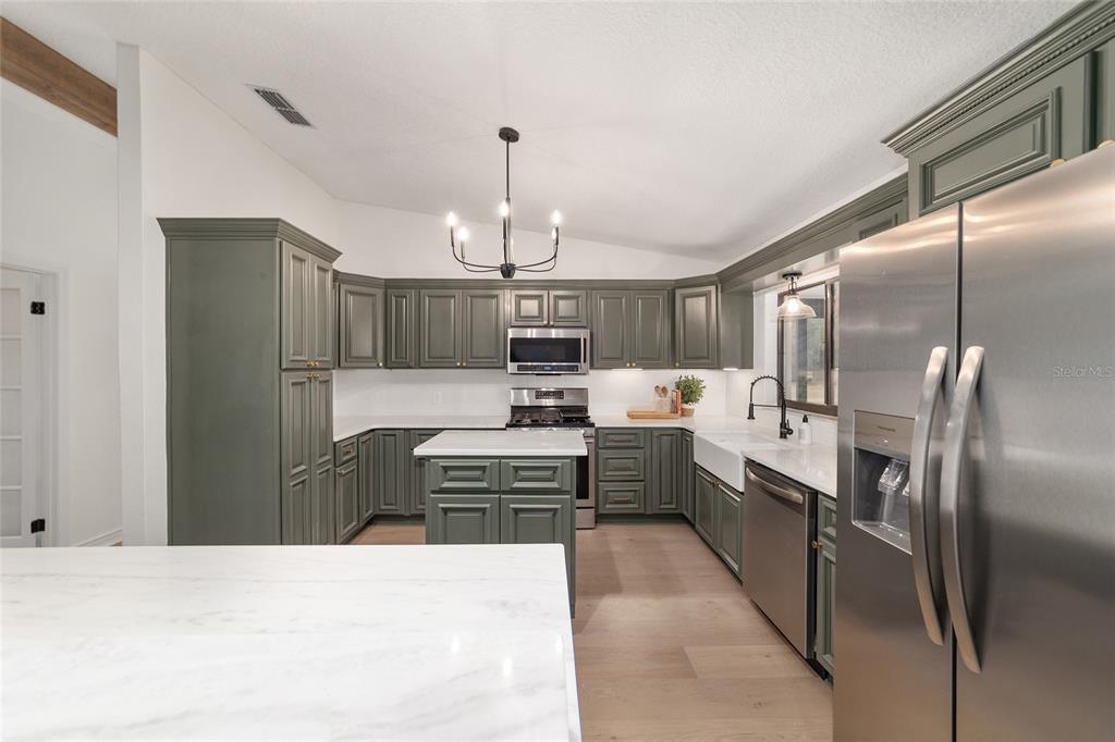 10575 Southwest 27th Avenue Ocala, FL 34476 - Photo 50 of 95 a kitchen with stainless steel appliances kitchen island granite countertop a refrigerator and a sink