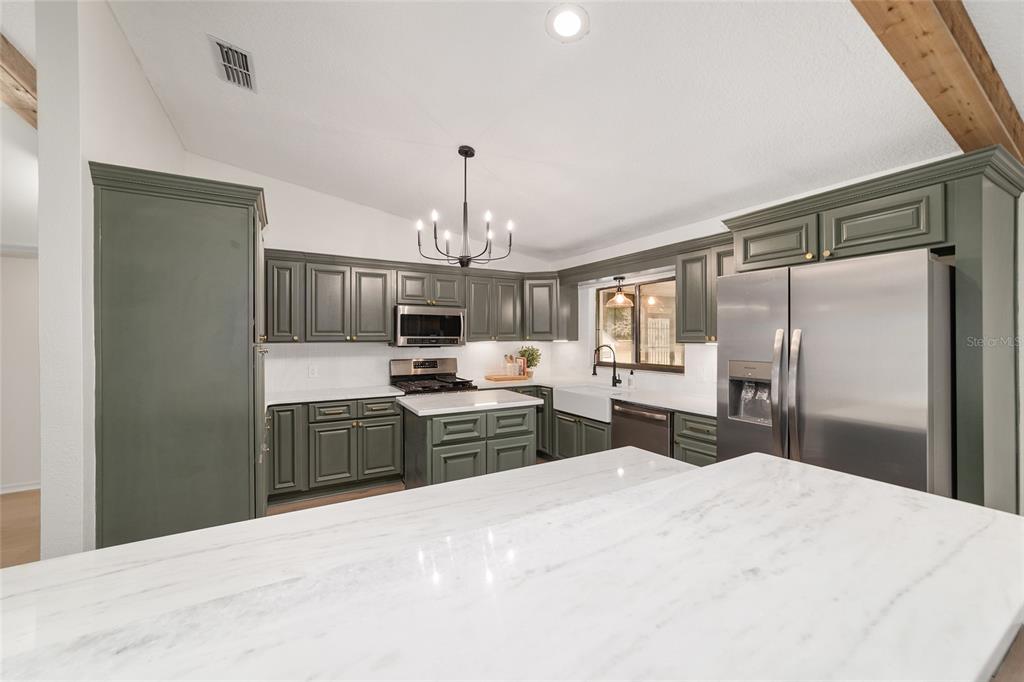 10575 Southwest 27th Avenue Ocala, FL 34476 - Photo 59 of 93 a kitchen with a refrigerator a sink and wooden floor
